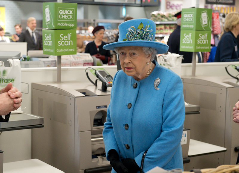 Queen Elizabeth II looks at products on the shelves at a Waitrose supermarket during a visit to the town of Poundbury on October 27, 2016 in Poundbury, Dorset. Photo via Getty Images.